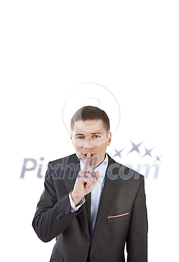Isolated businessman holding a finger in front of his mouth Isolated businessman holding a finger in front of his mouth