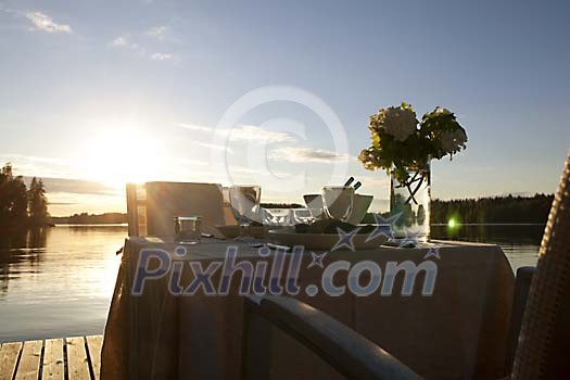 Table set by the water at the sunset Table set by the water at the sunset