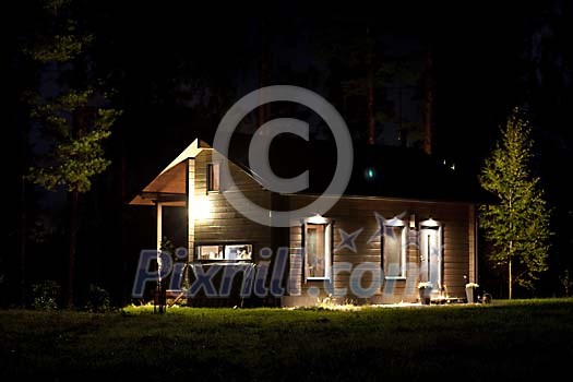 Lighted cottage in the dark night