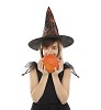 Girl dressed as a witch holding a pumpkin