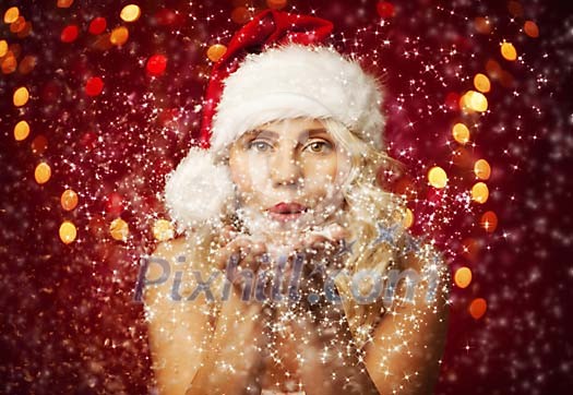 Christmas woman blowing magic dust to the camera