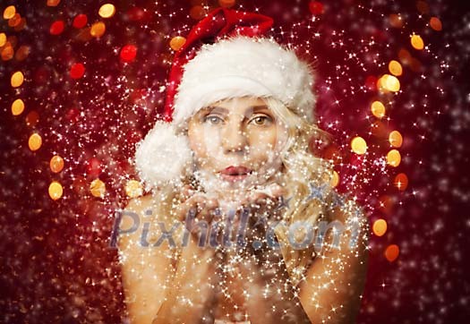 Christmas woman blowing magic dust to the camera Christmas woman blowing magic dust to the camera