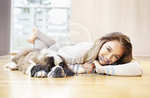 Woman lying on the floor with a puppy Woman lying on the floor with a puppy