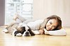 Woman lying on the floor with a puppy