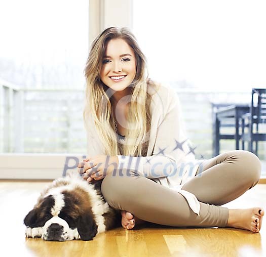 Woman sitting on the floor with a sleeping puppy
