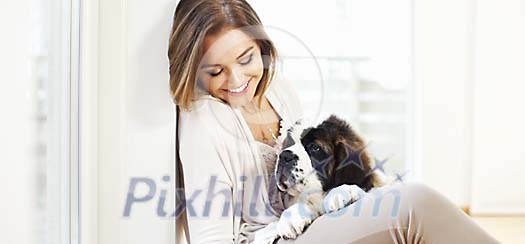 Woman smiling and looking at her puppy