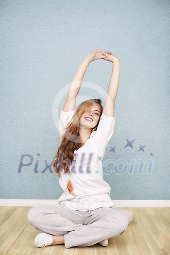 Young woman stretching on wooden floor