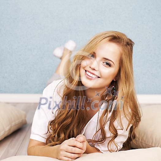 Smiling woman on the floor with pillows