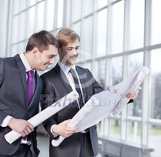 Two businessmen looking at the blueprint