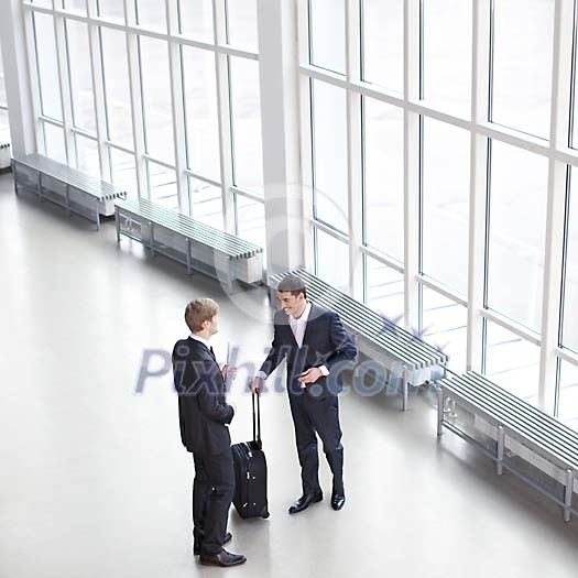 Businessmen having a conversation in the hall Businessmen having a conversation in the hall