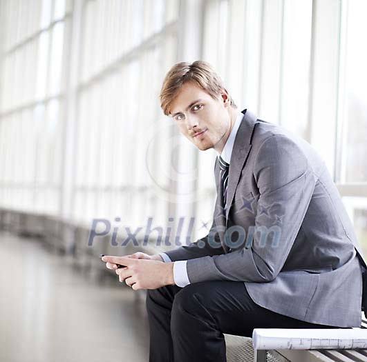 Young businessman sitting in the hall