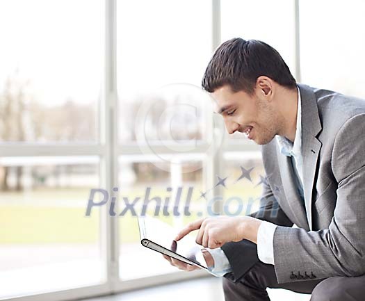 Businessman sitting with a tablet computer by the window