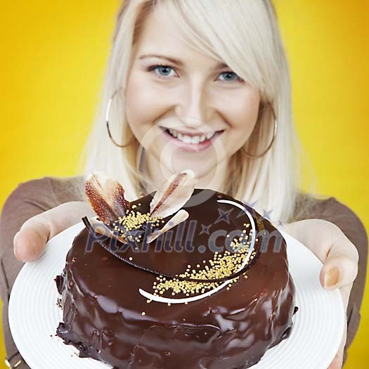 Woman offiring a chocolate cake on a plate Woman offiring a chocolate cake on a plate