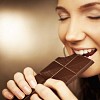 Woman taking a bite from a chocolate bar