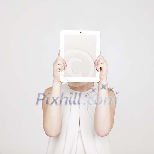 Woman hiding her face behind a tablet computer