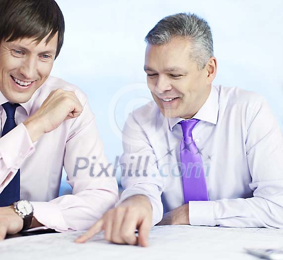 Businessmen looking at the blueprint Businessmen looking at the blueprint