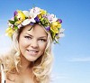 Face portrait of a beautiful blonde girl wearing a floral head wreath