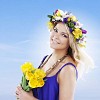 Natural scandinavian girl holding yellow flowers and wearing a floral head wreath