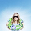 Little girl in sunglasses holding a swimming ring and looking at camera