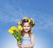 Little girl with floral head wreath and a big yellow flower bouquet