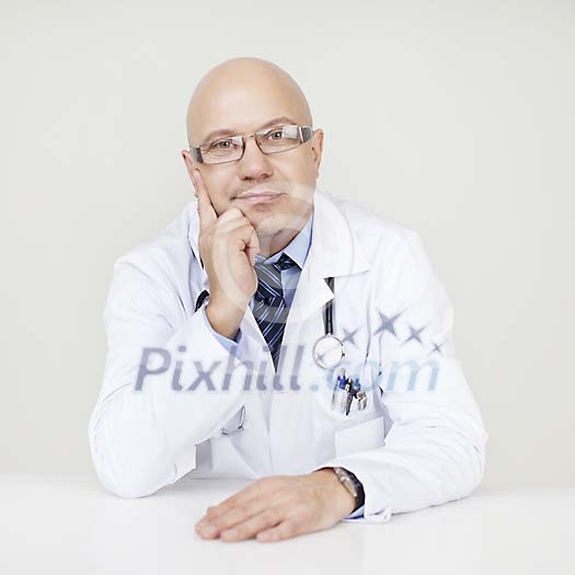 Male doctor sitting by the desk, listening