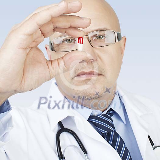 Male doctor holding a medicine capsule Male doctor holding a medicine capsule