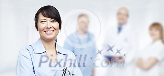 Smiling nurse with other staff