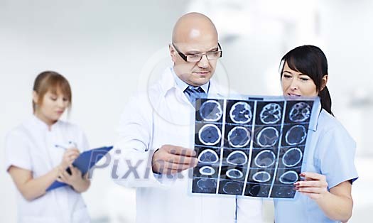 Doctor checking a CT scan with a nurse Doctor checking a CT scan with a nurse