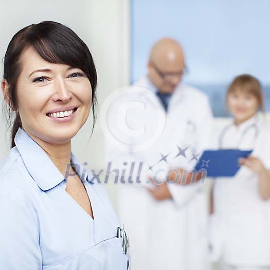 Smiling nurse with a doctor and another nurse