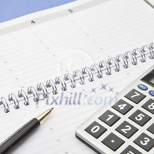 Calculator and a pen on an empty calendar