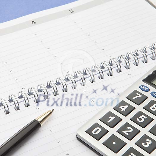 Calculator and a pen on an empty calendar Calculator and a pen on an empty calendar