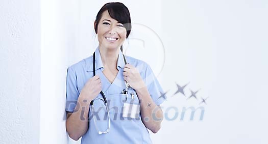 Smiling female nurse leaning against the wall Smiling female nurse leaning against the wall