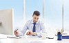 Businessman checking time by his work desk