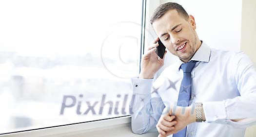 Man standing by the window, talking to a phone