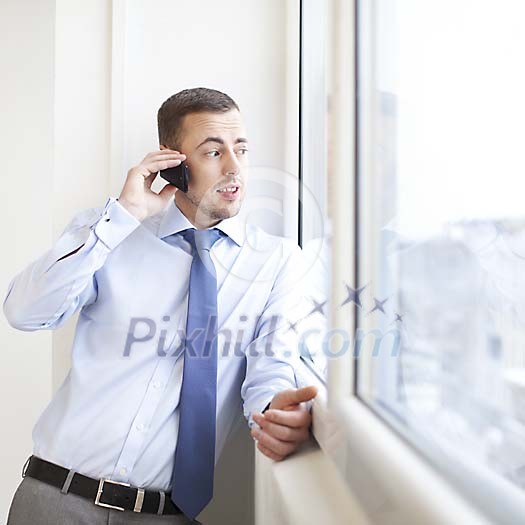 Man by the window, talking to a phone