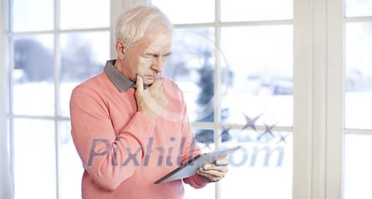 Senior man with ipad at home