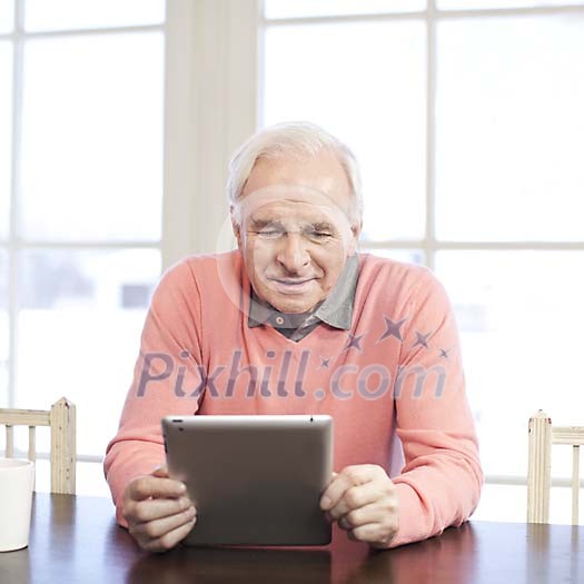 Senior man looking tablet computer screen at home