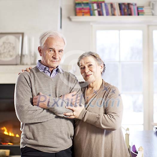 Happy senior couple in a beautiful home smiling at camera