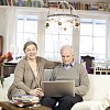 Senior couple sitting on a couch in a light, stylish home