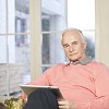 Senior man at home with tablet computer