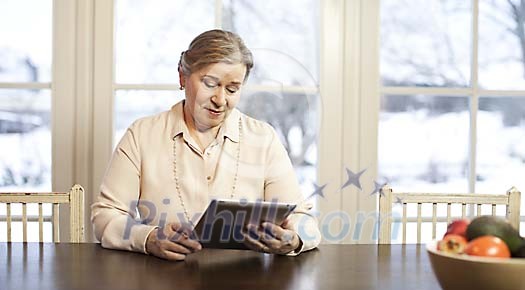 Senior woman with pad at home
