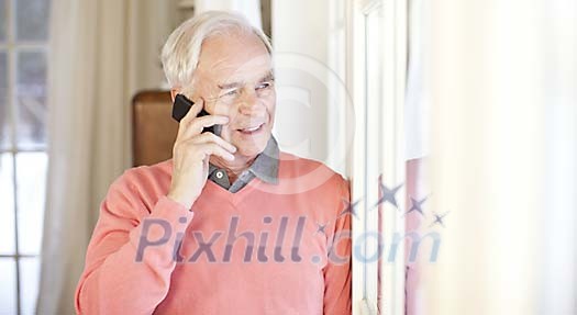 Senior man at home calling with mobile phone