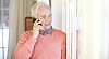 Senior man at home calling with mobile phone