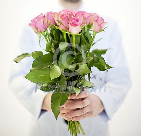 Male hands holding a bouquet of pink roses