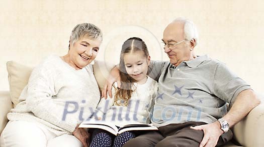 Child with her grandparents sitting on the sofa