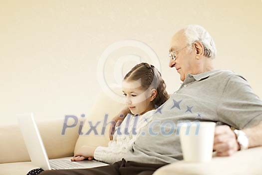 Girl with her grandpa sitting on the sofa