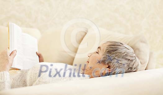 Older female reading on the sofa Older female reading on the sofa