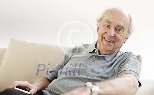 Older male smiling on the sofa