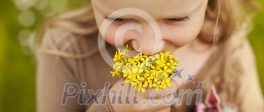 Small girl smelling self picked flowers