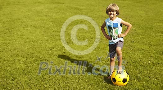 Little boy with a plastic football on the grass